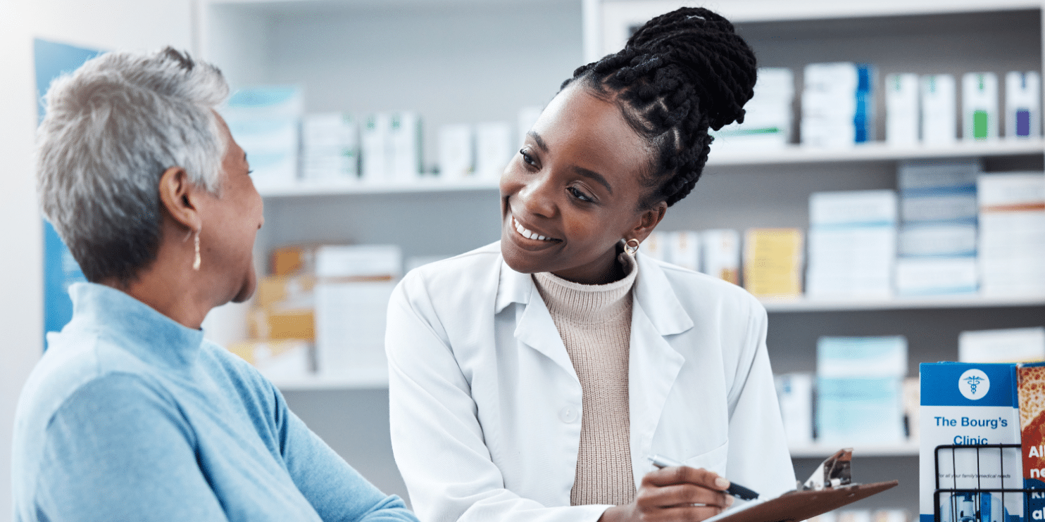 Understanding The Role Of Pharmacy Assistants In Alberta ABES   Patient Looking At Medicinal Documents With Pharmacy Assistant 1500 X750 1484x742 