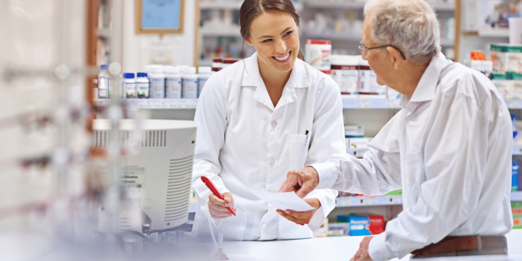 Pharmacy Assistant helping elderly patient read medication list - Pharmacy Assistant vs. Pharmacy Technician: Which Career is Right for You?