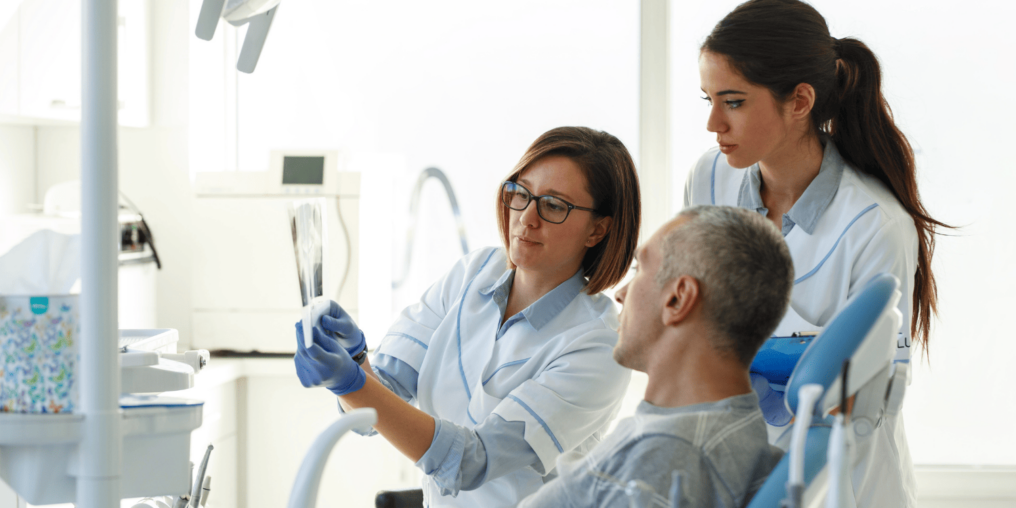 Dental Office Assistant working with Dentist looking at x-ray - 5 Things You'll Learn in a Dental Office Assistant (DOA) Program